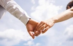Primer plano de una pareja cogida de la mano al aire libre.